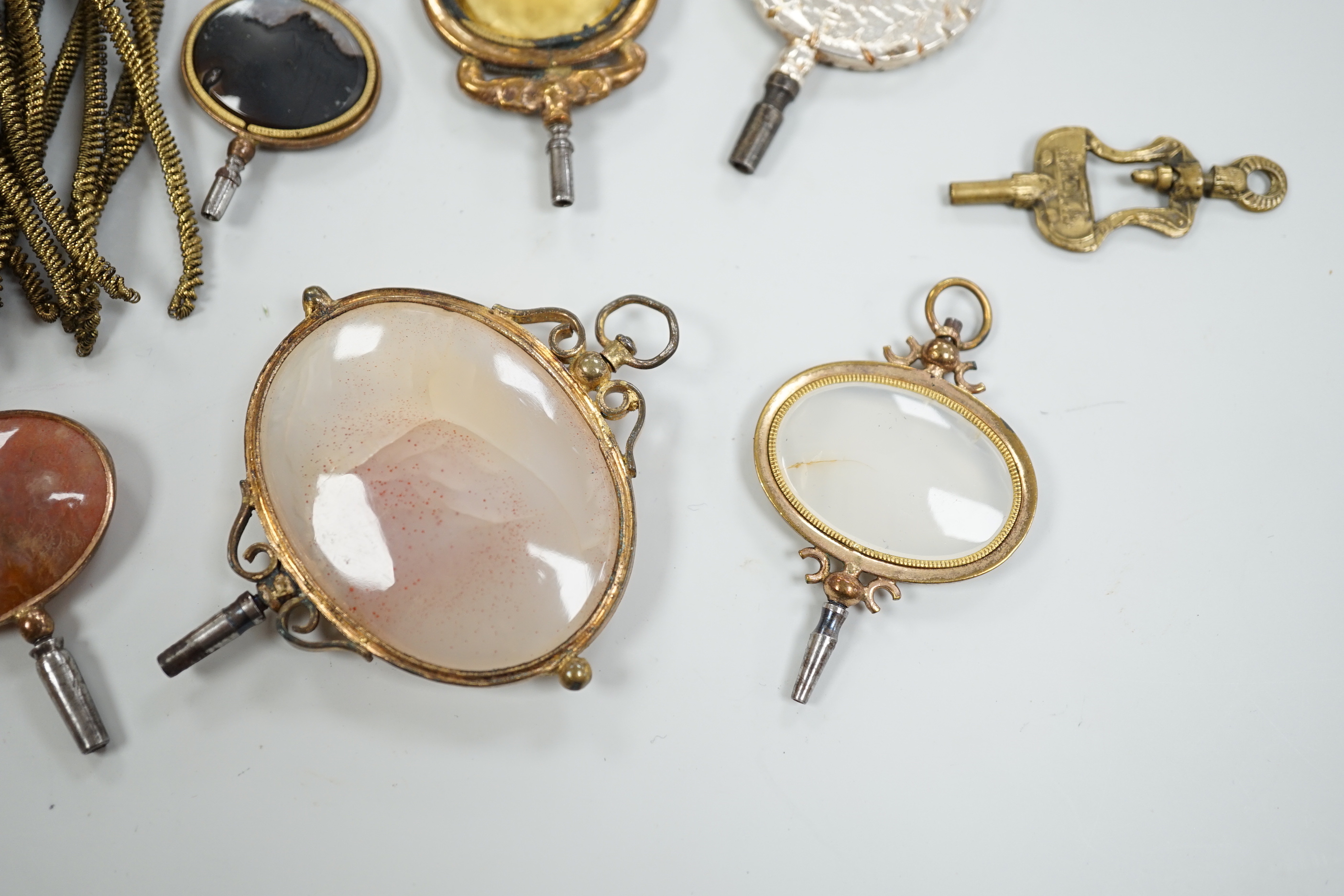 Ten assorted mainly 19th century base or yellow metal oval and gem set large watch keys, including agate and citrine paste and one set with French medallion, largest 69mm.